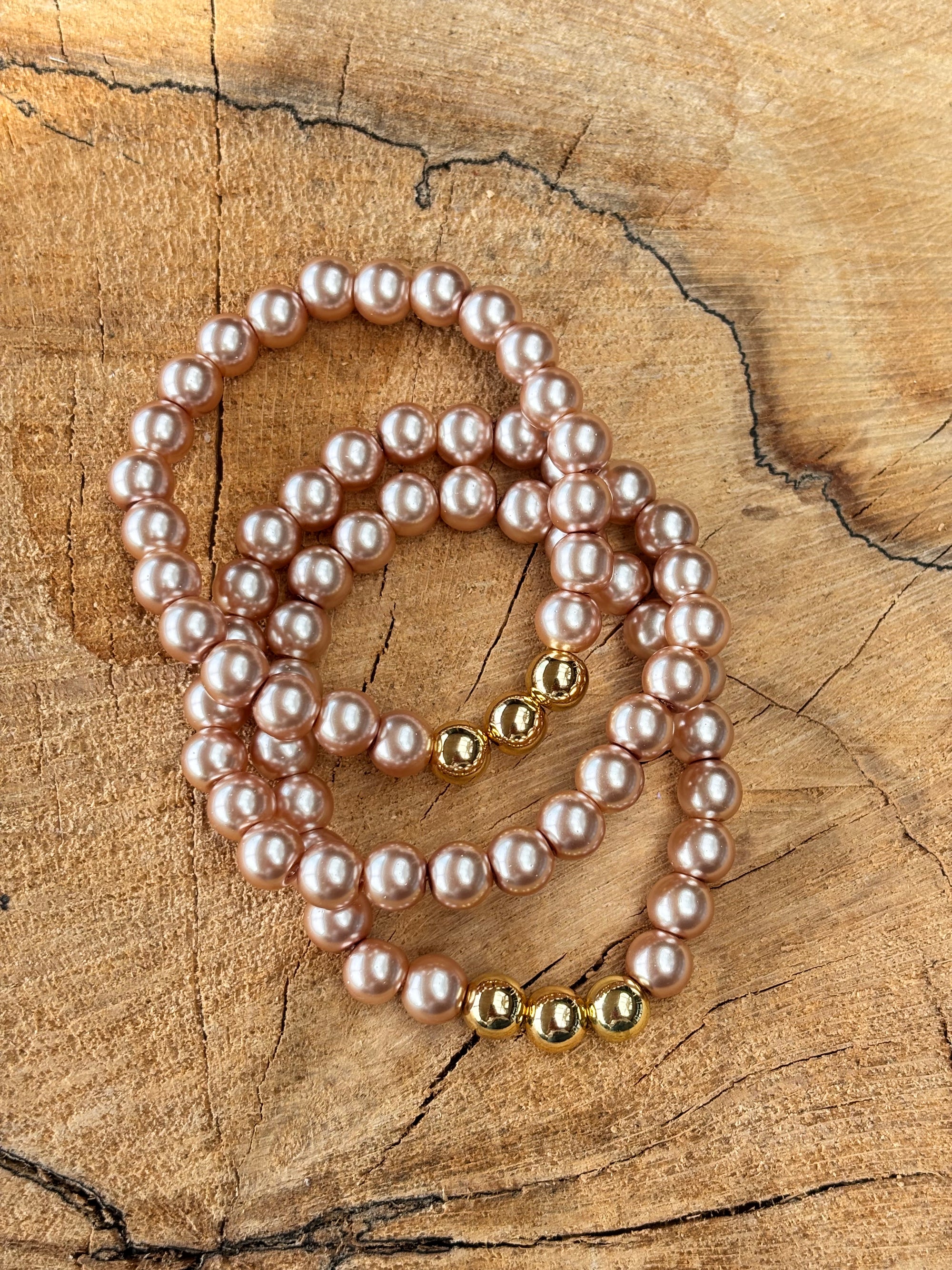 Stretch parel armband in taupe brown met gouden accenten.