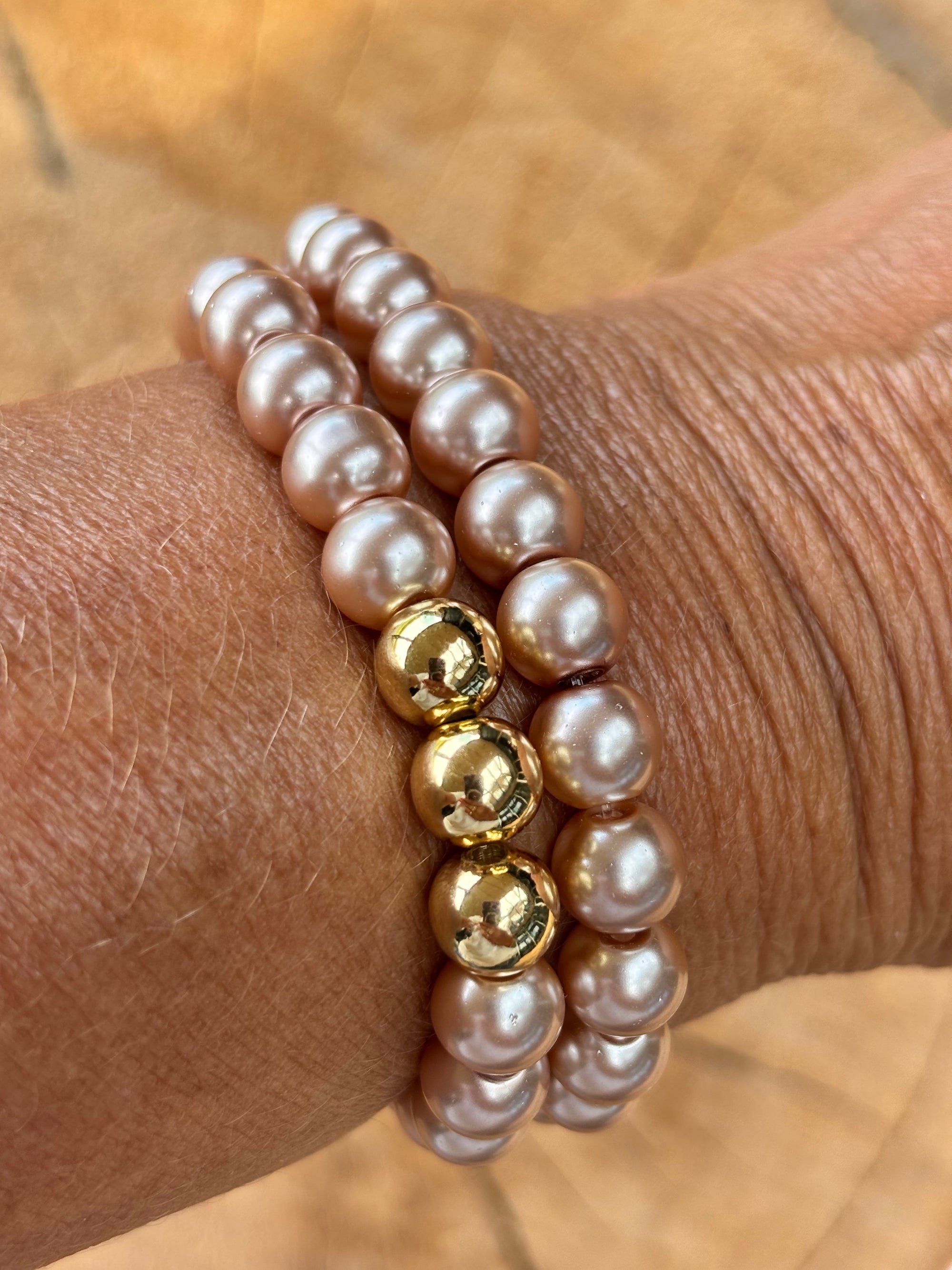 Stretch parel armband in taupe brown met gouden accenten.